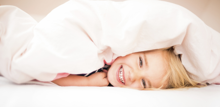 Child hiding under the covers